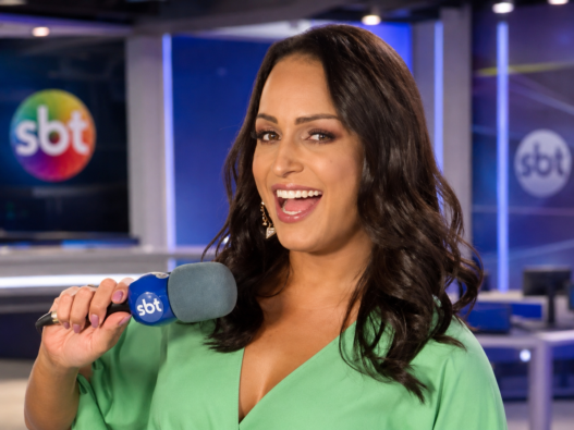 Lisa Gomes em estúdio do SBT com microfone durante conteúdo sobre comunicação e representatividade