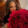 Gisele segura um grande buquê de rosas vermelhas em foto relacionada aos rumores de romance com Rebeca Andrade
